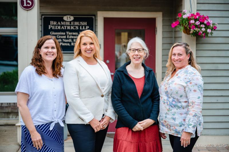 four women in front of a building